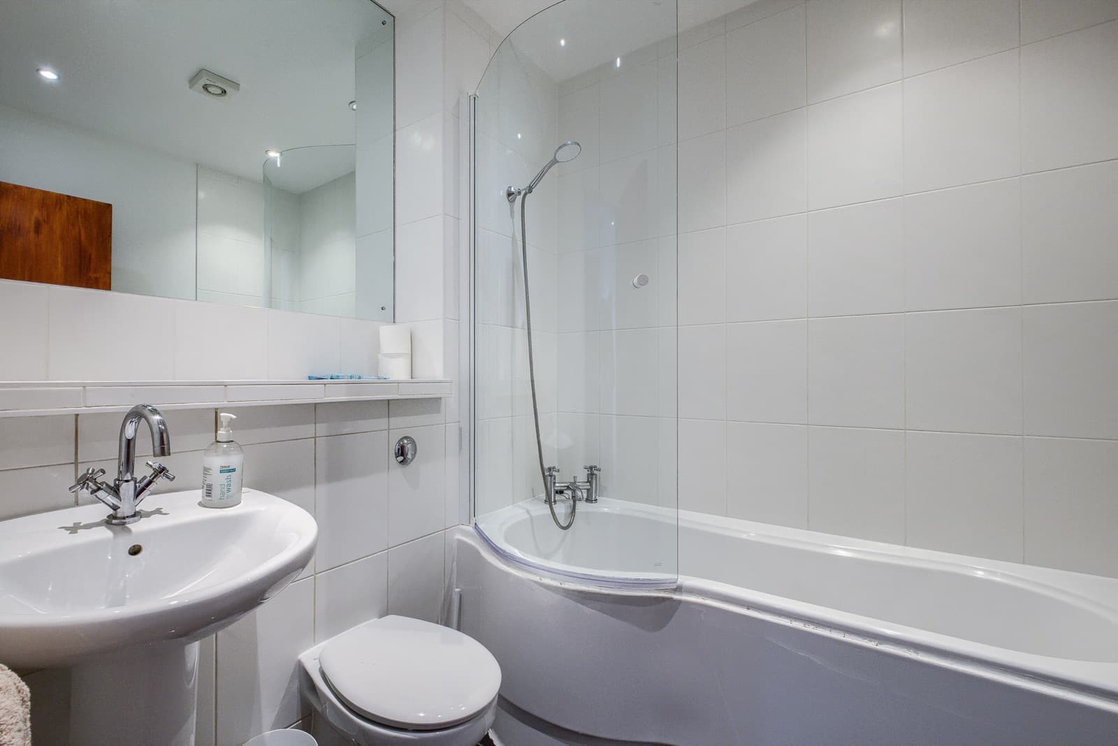 The bathroom of the Leamington flat, white-tiled and immaculate